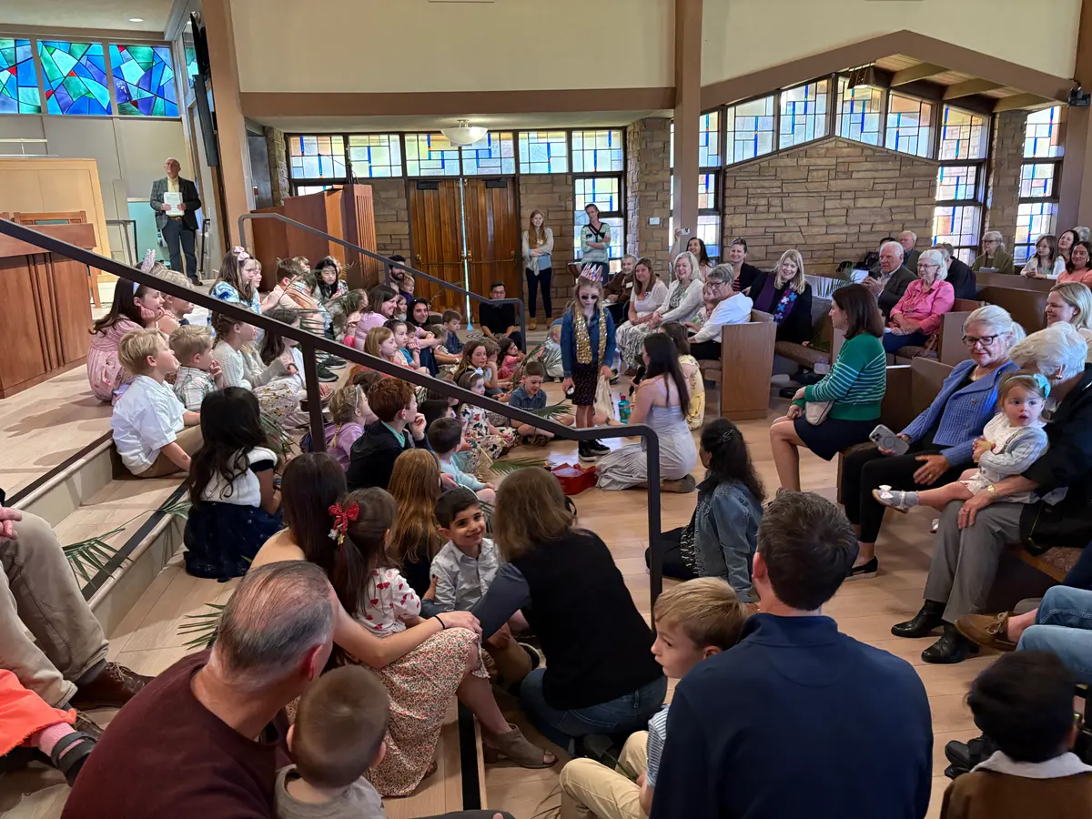 Children gathered around the chancel during Sunday worship at PCLG.