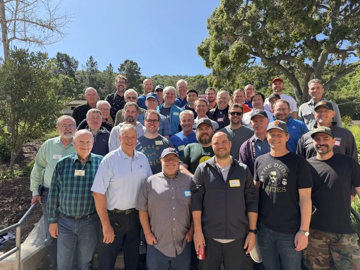 The men’s retreat group standing under oak trees.