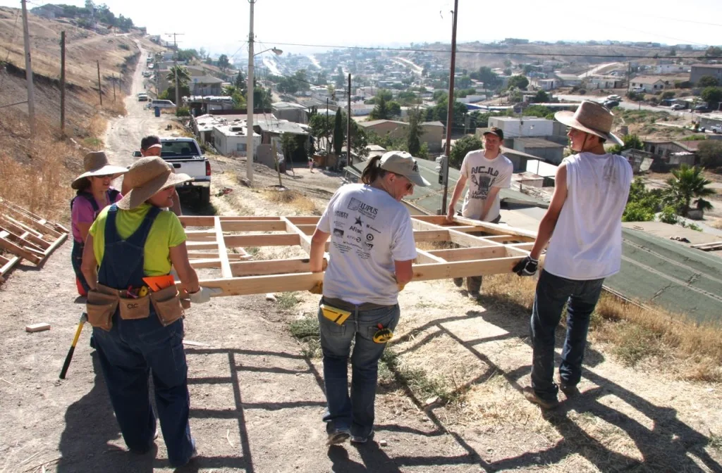 PCLG volunteers carrying a framed wall on an Amor Ministries home build in Mexico.