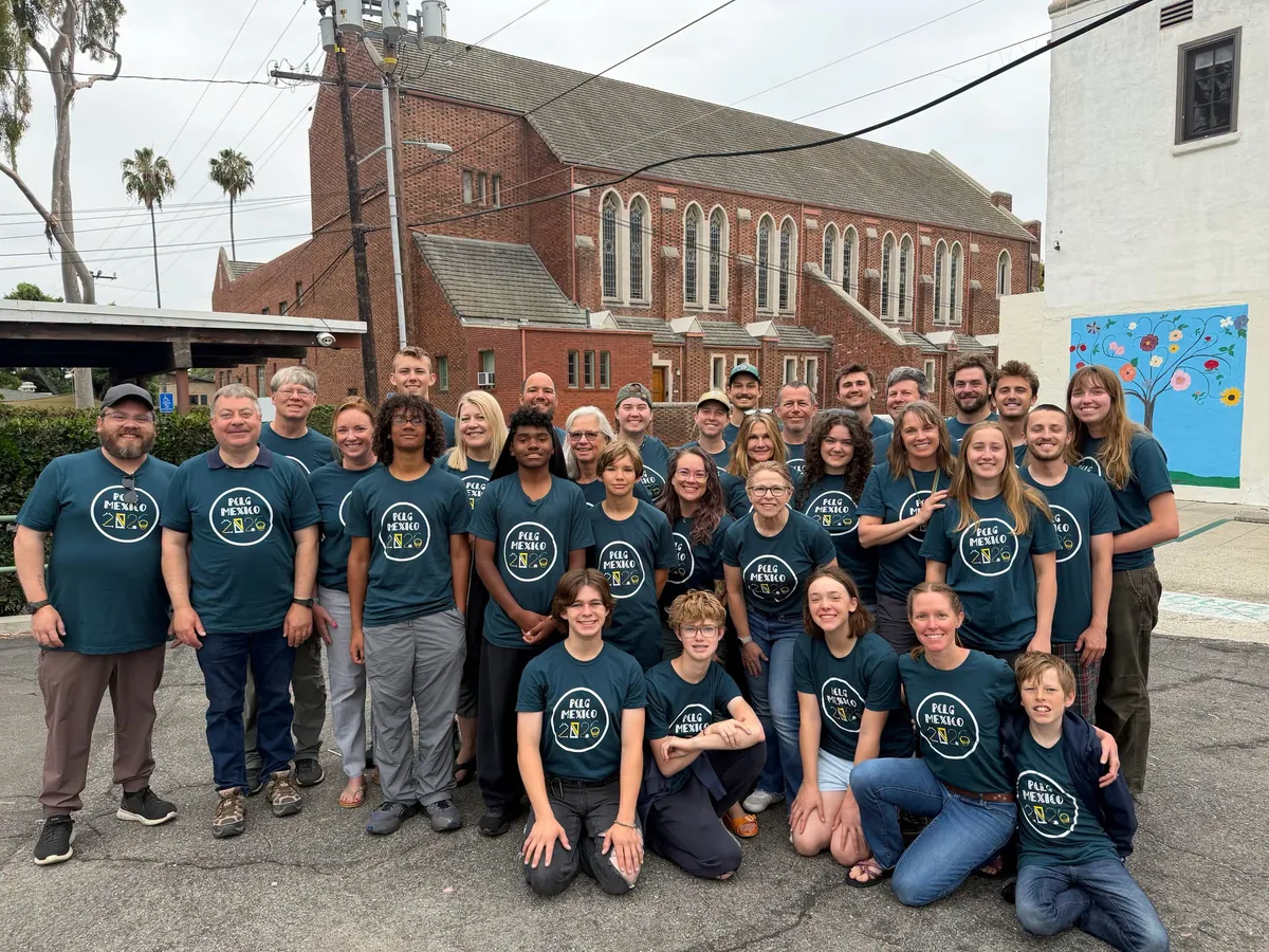 The all-church Mexico build team in matching PCLG MEXICO shirts outside a brick church on the trip.