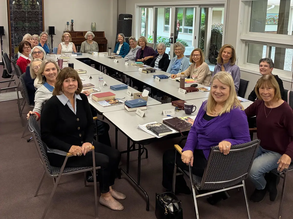 The WOW women’s Bible study seated around long tables in the Fireside Room, Bibles open.