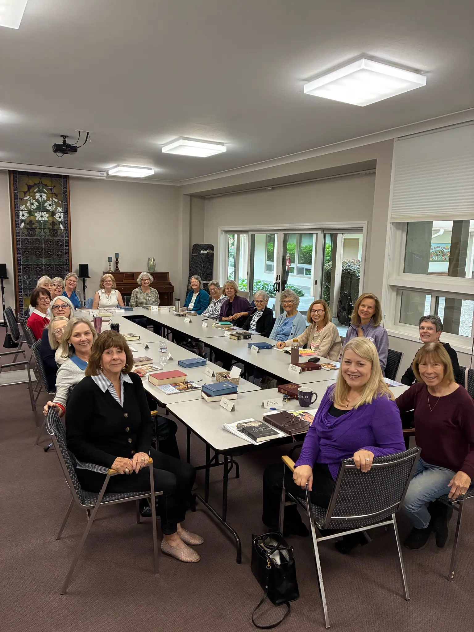 The WOW women’s Bible study seated around long tables in the Fireside Room, Bibles open.